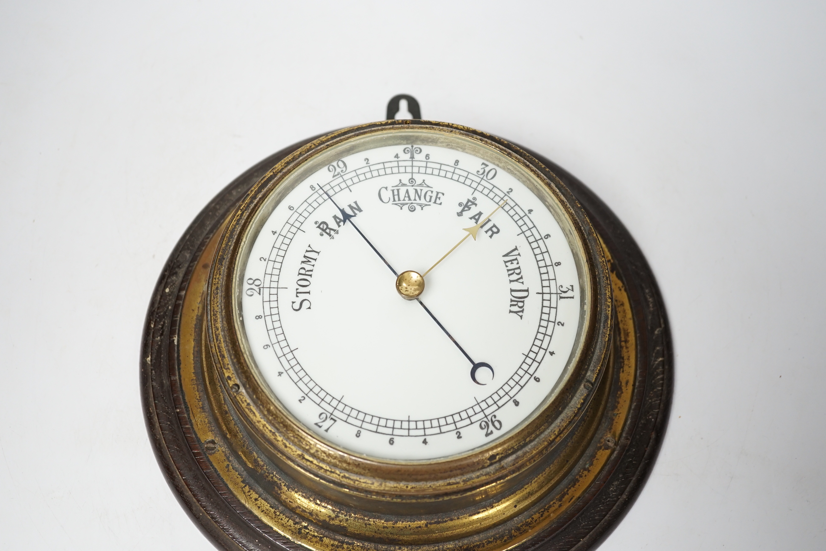 A wooden mounted wall circular aneroid barometer, 28cm diameter